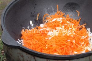 <p>Морковь трем на крупной тёрке или нарезаем соломкой и добавляем обжариваться к луку.</p>
