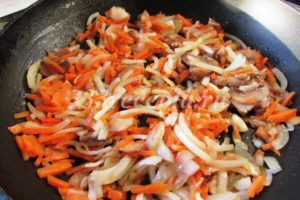 <p>Репчатый лук и морковь нарезаем и обжариваем вместе с грибами до мягкости.</p>
