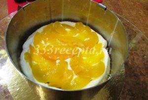 <p>1/3 творожного крема выкладываем на корж. На крем выкладываем подготовленную половину персиков (не выкладываем персики у самого края).</p>
